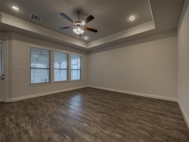 unfurnished room featuring visible vents, crown molding, a raised ceiling, and dark wood-style flooring