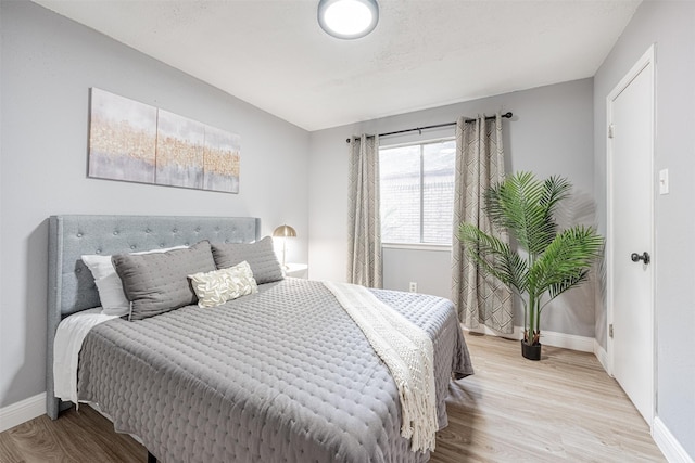 bedroom with baseboards and wood finished floors