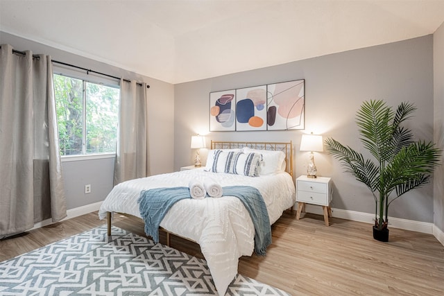 bedroom with light wood-type flooring and baseboards