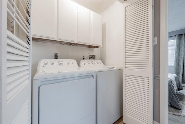 laundry room featuring washing machine and dryer and cabinet space