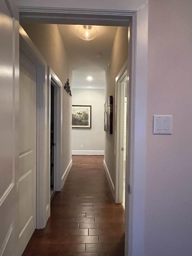 hallway with baseboards and dark wood-type flooring