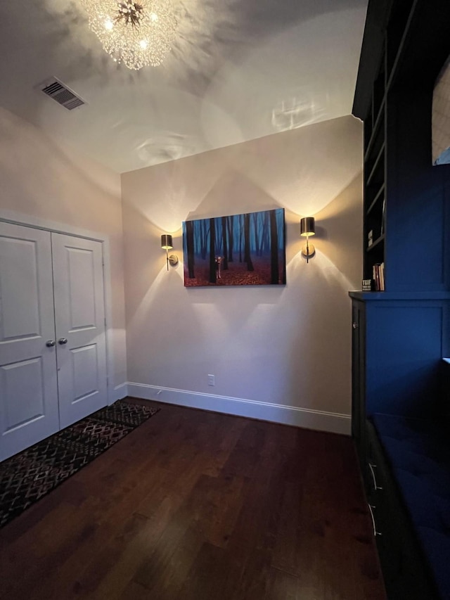 interior space featuring a notable chandelier, visible vents, baseboards, and dark wood-style flooring