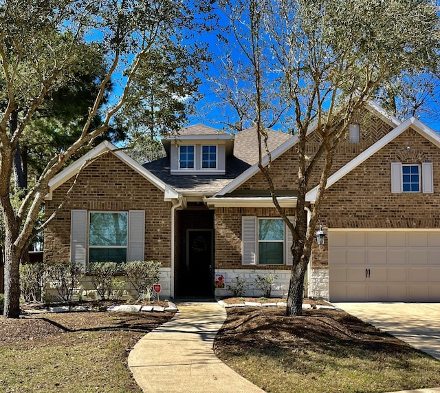 view of front of house featuring stone siding, concrete driveway, brick siding, and roof with shingles