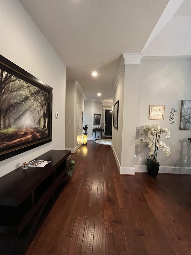 hall featuring hardwood / wood-style flooring, recessed lighting, baseboards, and ornamental molding