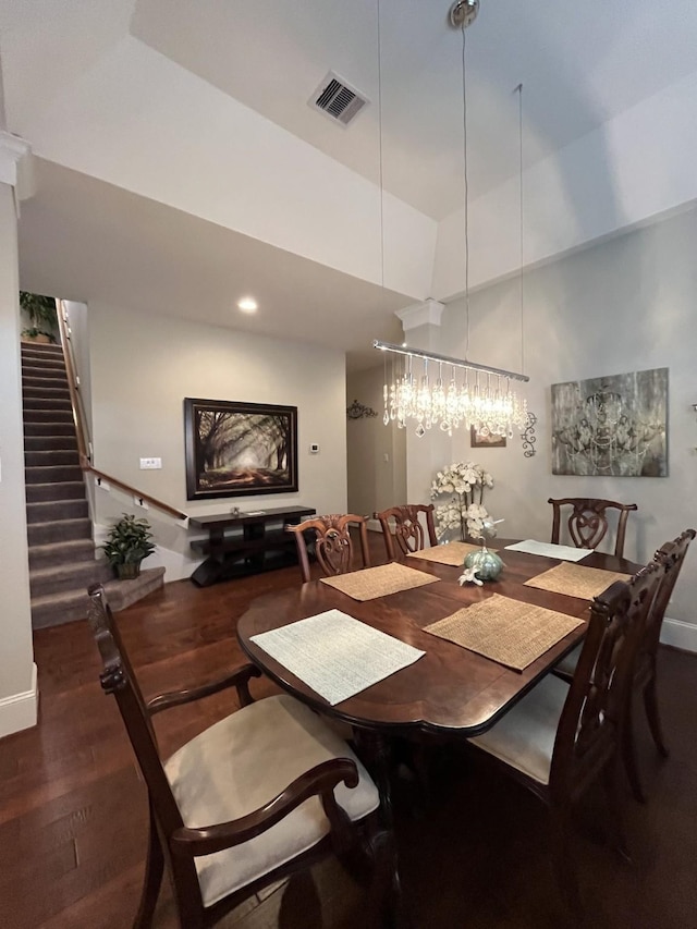 dining space featuring stairs, dark wood finished floors, visible vents, and baseboards