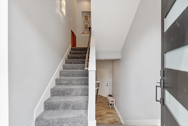 staircase with baseboards and wood finished floors