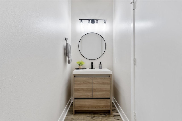 bathroom featuring vanity, wood finished floors, and baseboards