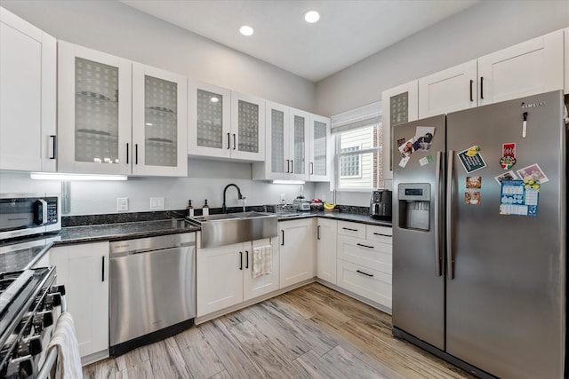 kitchen featuring a sink, stainless steel appliances, and white cabinetry