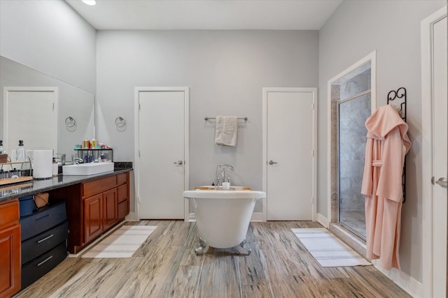 full bathroom with vanity, a soaking tub, wood finished floors, and a stall shower