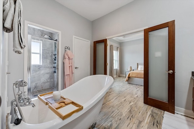 full bathroom with wood finished floors, baseboards, tiled shower, a soaking tub, and connected bathroom