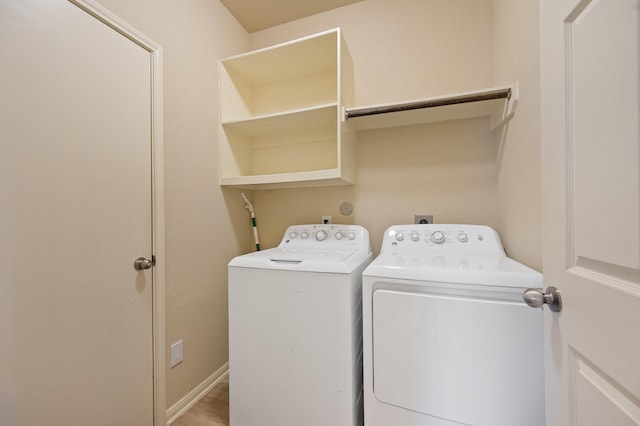 clothes washing area with laundry area, washer and clothes dryer, and baseboards