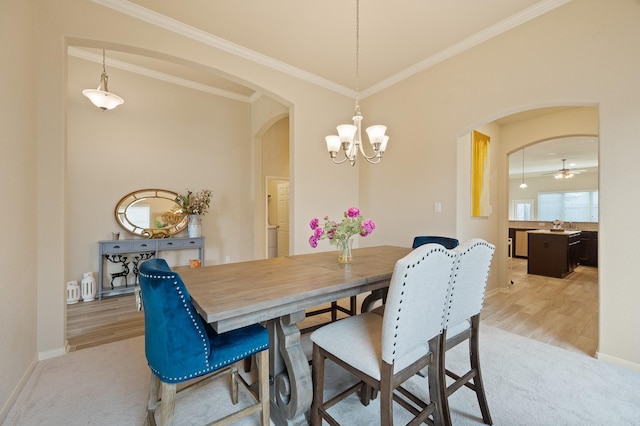 dining space with light carpet, arched walkways, and ornamental molding