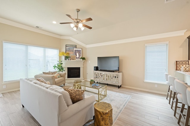 living room featuring ceiling fan, light wood-type flooring, visible vents, and crown molding