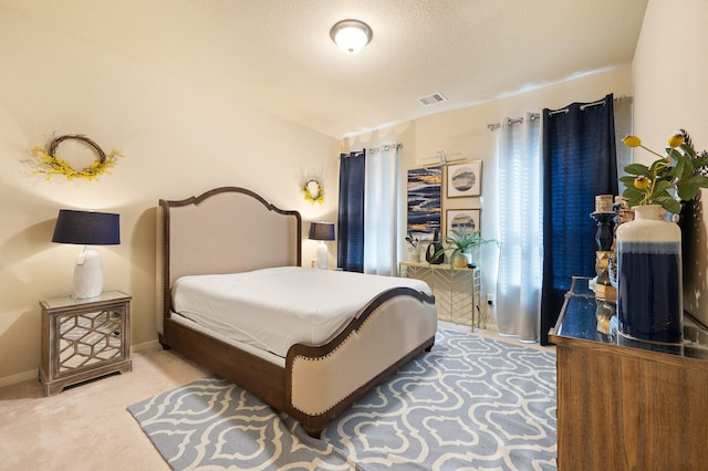 bedroom with baseboards, a textured ceiling, visible vents, and carpet flooring