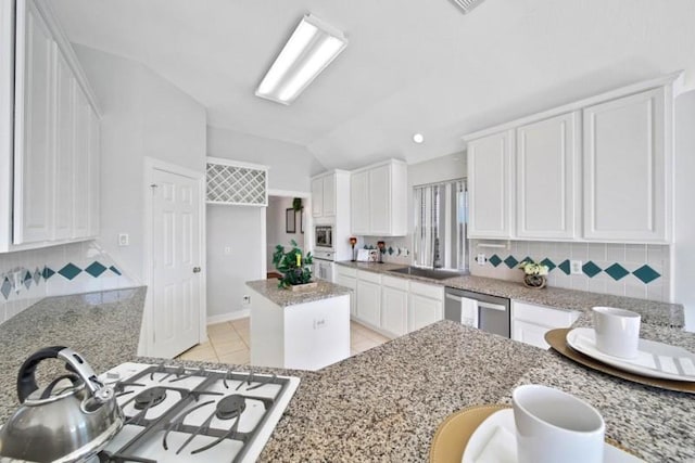 kitchen featuring light tile patterned floors, white appliances, a sink, white cabinetry, and tasteful backsplash