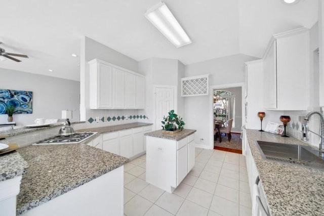 kitchen featuring light tile patterned flooring, a sink, white cabinetry, gas cooktop, and light stone countertops