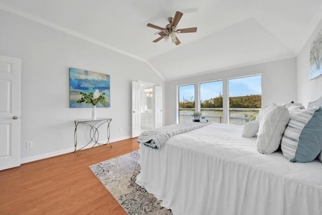 bedroom with baseboards, lofted ceiling, ceiling fan, wood finished floors, and crown molding