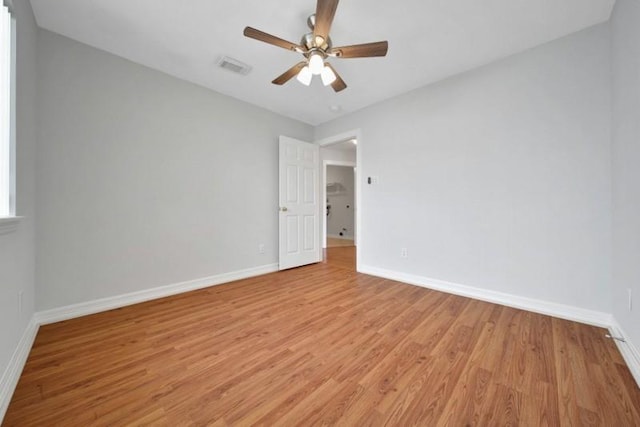 unfurnished room with visible vents, a ceiling fan, light wood-style flooring, and baseboards