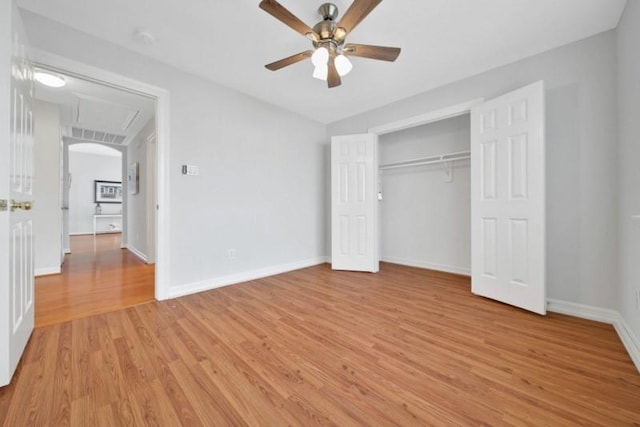 unfurnished bedroom featuring baseboards, ceiling fan, a closet, and light wood-style floors