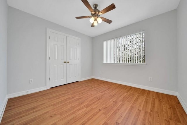 unfurnished bedroom with baseboards, a closet, and light wood-style floors