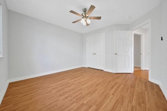 unfurnished bedroom with light wood-type flooring, a closet, ceiling fan, and baseboards