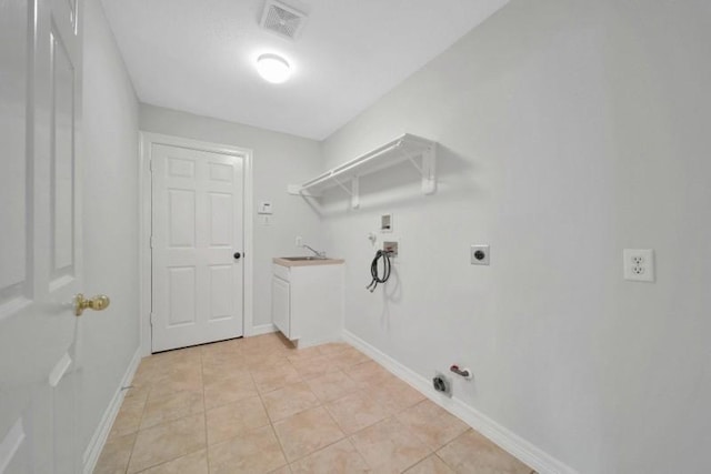 washroom featuring baseboards, hookup for a gas dryer, hookup for a washing machine, electric dryer hookup, and light tile patterned flooring