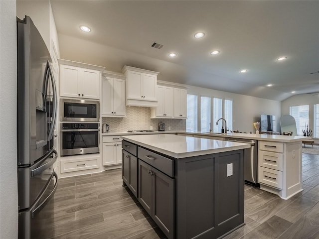 kitchen with visible vents, a peninsula, light countertops, appliances with stainless steel finishes, and white cabinetry