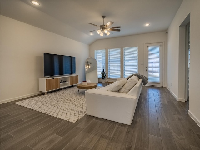 living area featuring dark wood-style floors, baseboards, lofted ceiling, and a ceiling fan