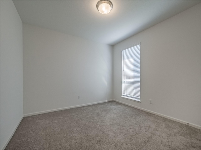 carpeted spare room with baseboards