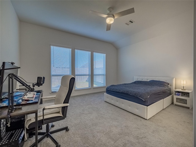 carpeted bedroom with lofted ceiling, a ceiling fan, and visible vents