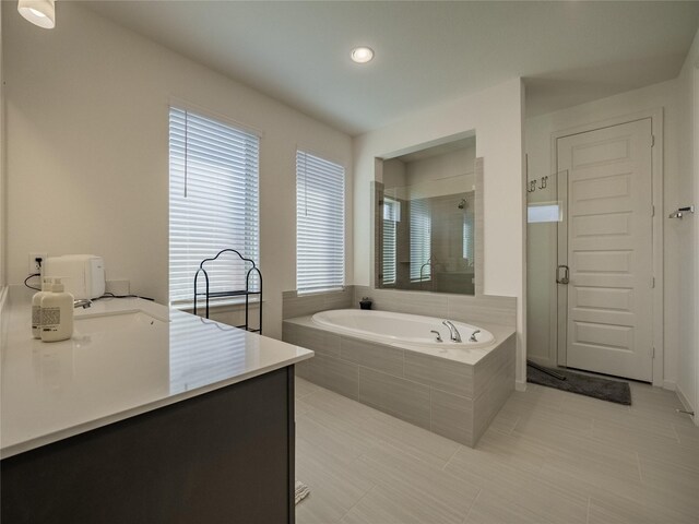 bathroom with a bath, a stall shower, and vanity