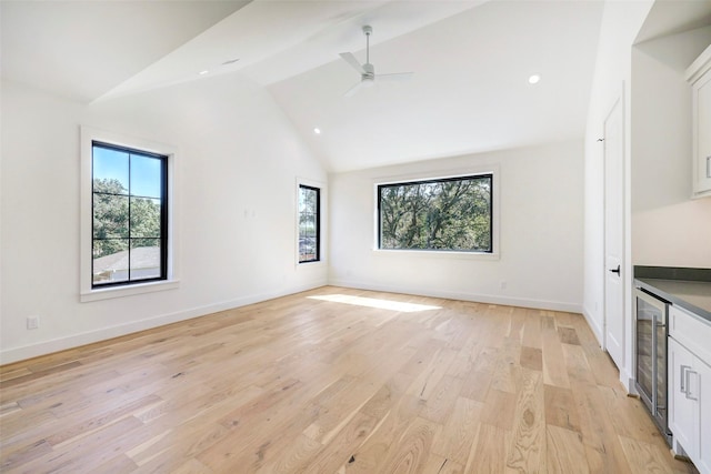 unfurnished room featuring a ceiling fan, beverage cooler, light wood-type flooring, and baseboards