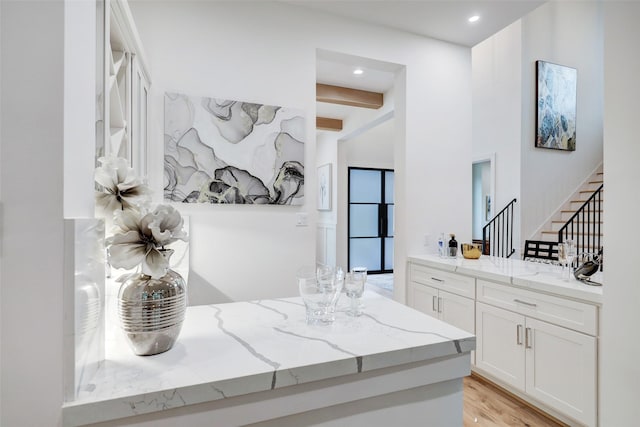 bathroom with vanity, beamed ceiling, recessed lighting, and wood finished floors