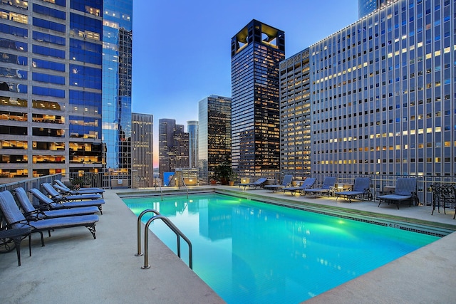 community pool with a view of city and a patio