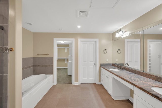 full bath with tile patterned flooring, a garden tub, double vanity, and a sink