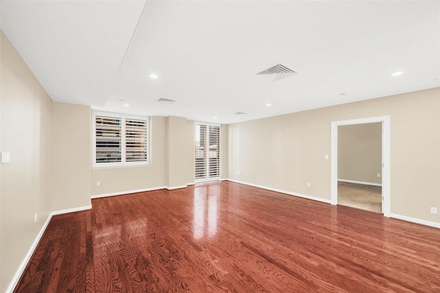 unfurnished room featuring visible vents, recessed lighting, baseboards, and wood finished floors