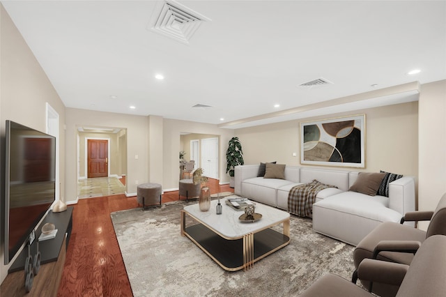 living area with recessed lighting, wood finished floors, and visible vents