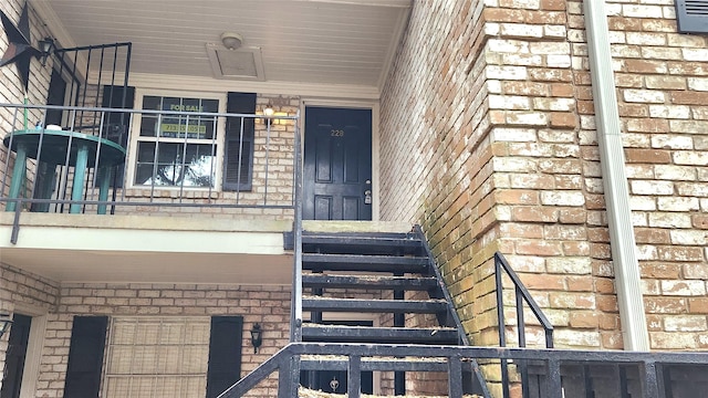 entrance to property featuring brick siding