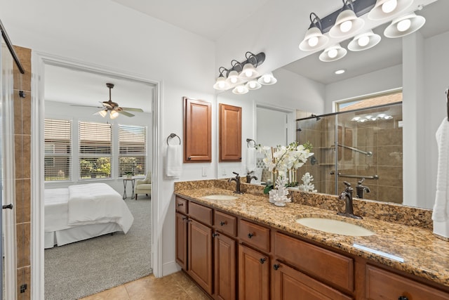 bathroom with a sink, tiled shower, double vanity, and tile patterned floors