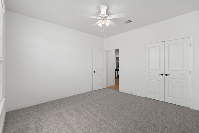 unfurnished bedroom featuring carpet, visible vents, a closet, and baseboards