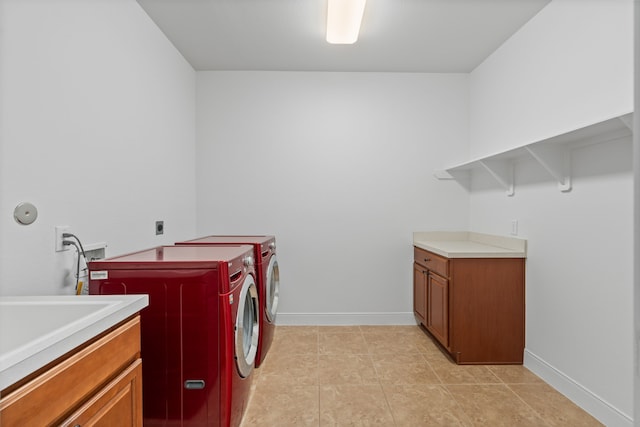 laundry area featuring cabinet space, baseboards, independent washer and dryer, and light tile patterned flooring