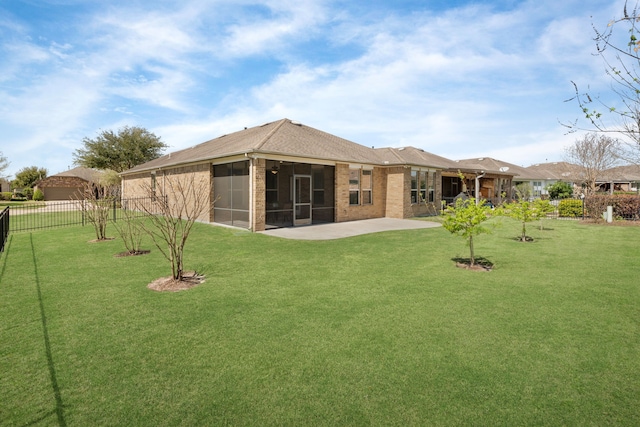 back of property with a patio, fence, a sunroom, a lawn, and brick siding