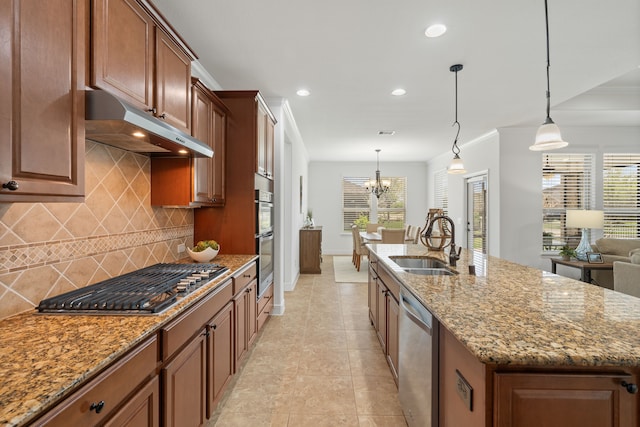 kitchen featuring light stone countertops, under cabinet range hood, an island with sink, appliances with stainless steel finishes, and a sink