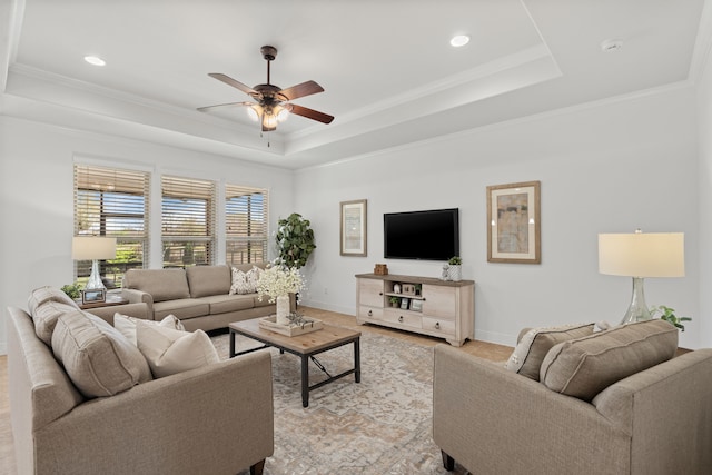 living room featuring a tray ceiling, crown molding, and ceiling fan