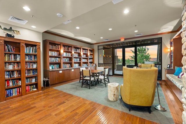 sitting room featuring visible vents, crown molding, and wood finished floors