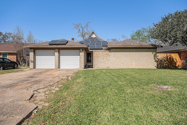 view of front of house featuring brick siding, solar panels, a front lawn, concrete driveway, and a garage