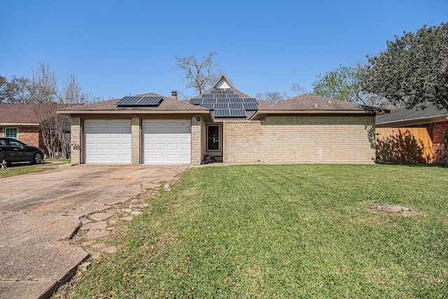 view of front of home with driveway, a front lawn, an attached garage, brick siding, and solar panels