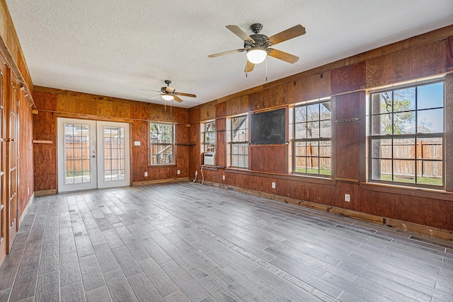 unfurnished sunroom with plenty of natural light, french doors, cooling unit, and ceiling fan