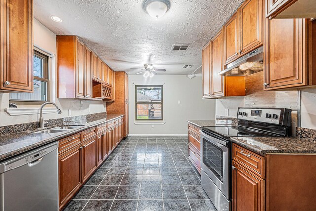 kitchen with a ceiling fan, visible vents, a sink, under cabinet range hood, and appliances with stainless steel finishes
