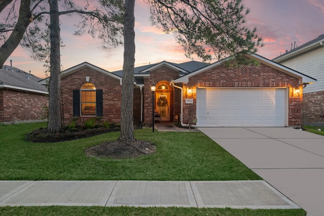 ranch-style home featuring a garage, concrete driveway, brick siding, and a lawn